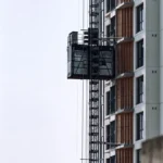 Construction hoist running up the facade of a building under construction