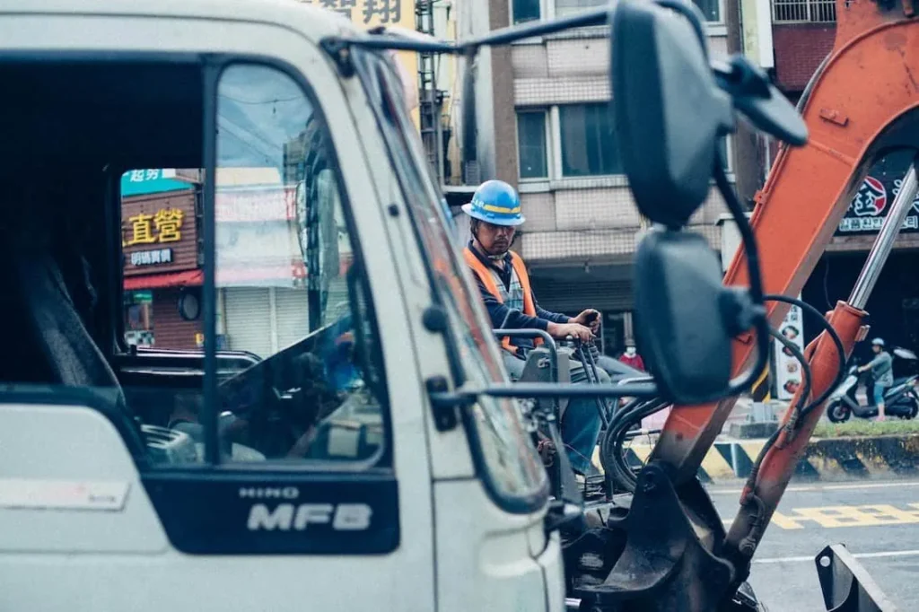Truck driver and excavator operator working on a site
