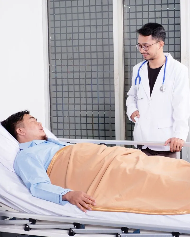 Doctor attending a patient resting in a hospital bed