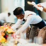 Hotel waiter setting a dining table