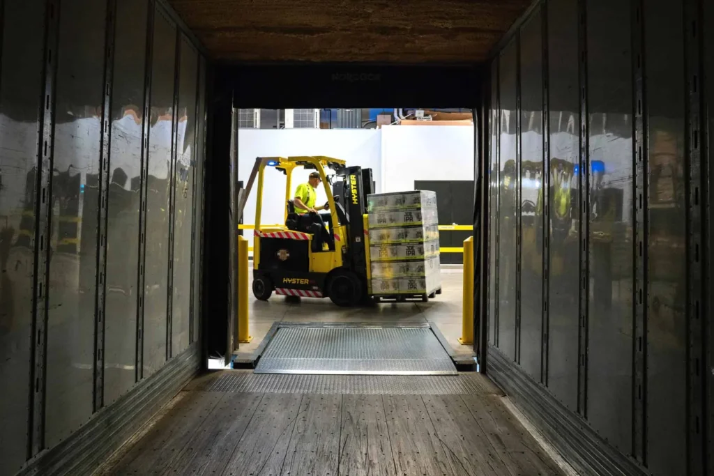 Forklift moving pallets at a warehouse loading bay