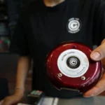Cafe staff holding a wireless customer pager at the order counter