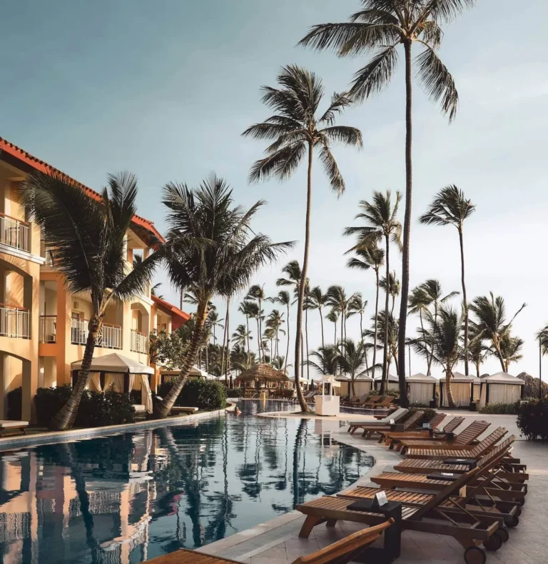 Hotel pool deck with sun loungers and palm trees