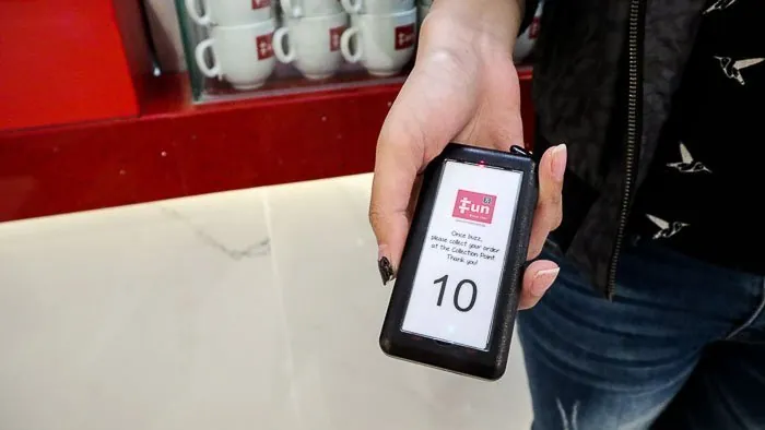 Series Slim pager showing number 10 at a takeaway counter