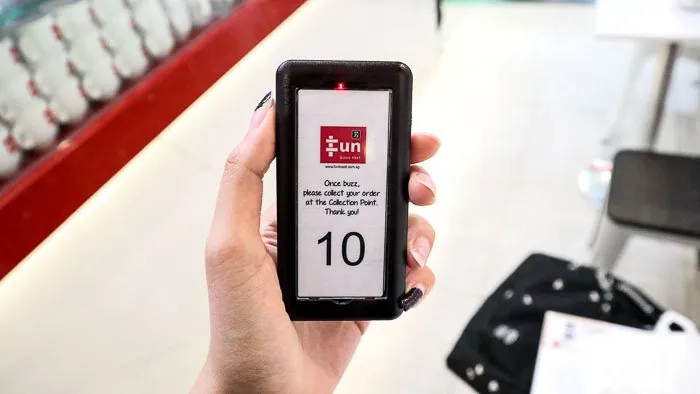Hand holding a Series Slim pager at the counter