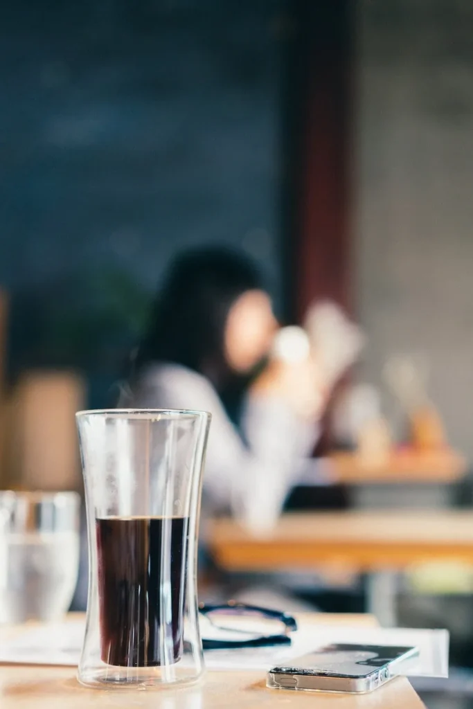 Customer with a drink at a cafe table