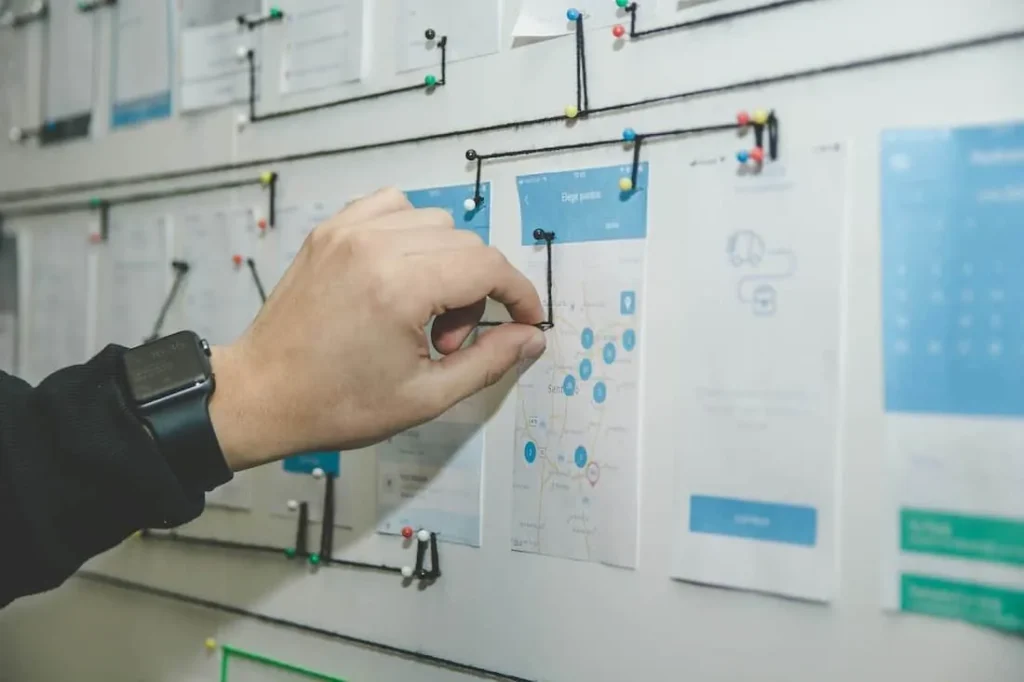 Hand pointing at a customer-flow chart on a whiteboard