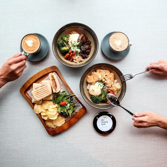 Overhead view of a cafe table with coffee, food and a customer pager